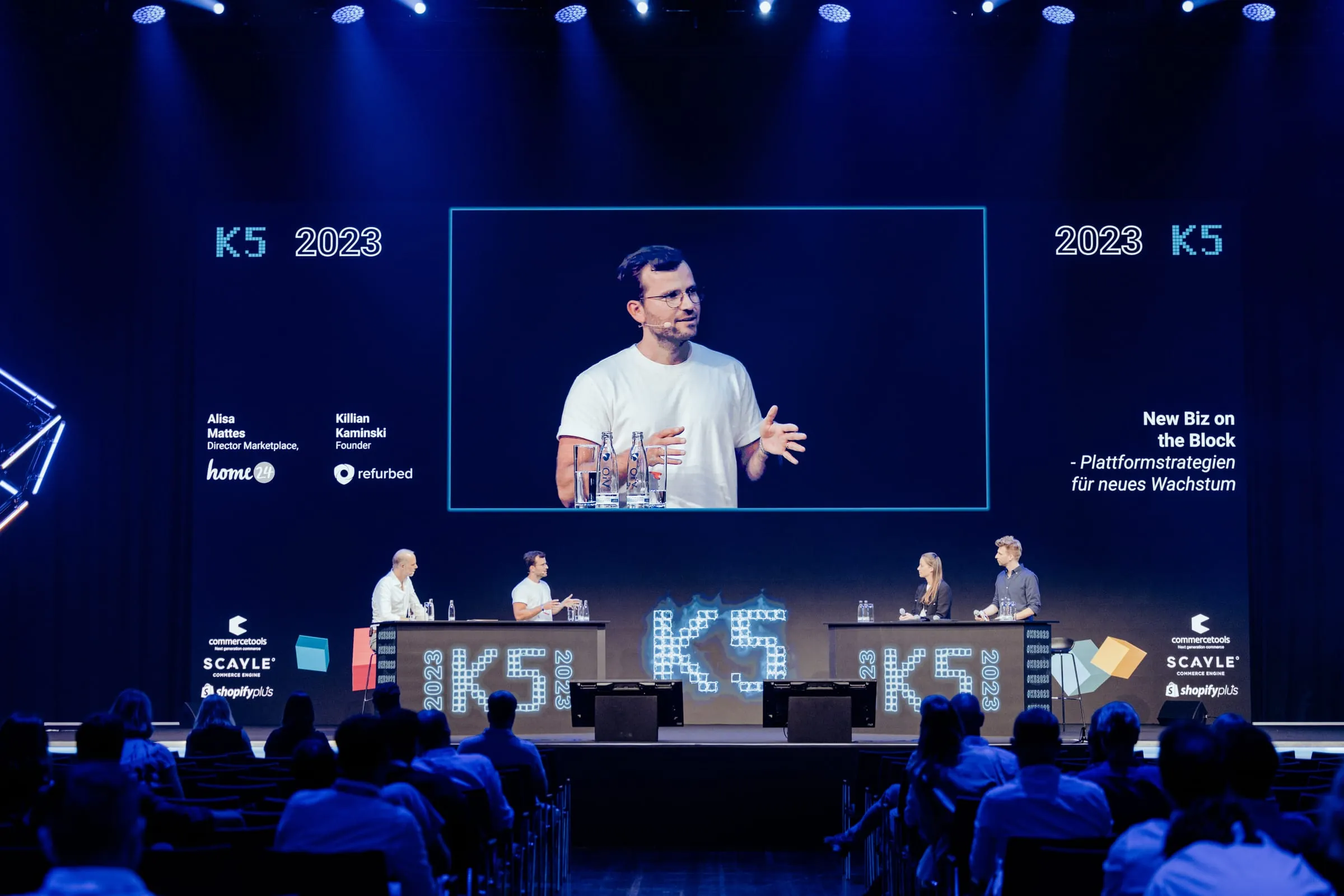 Philip Kehela auf der großen Leinwand der K5 Konferenz 2023 beim Panel zu Plattformstrategien